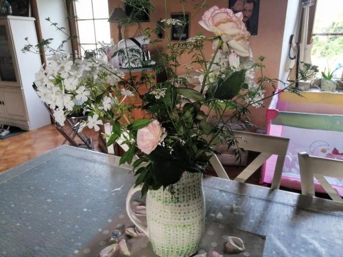 um vaso cheio de flores sentado numa mesa em Chambre d'hôtes La Montjoie em La Souris