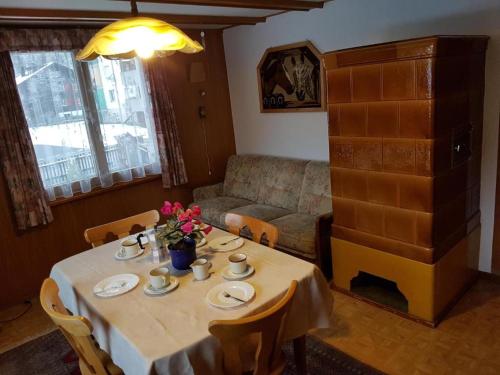 una mesa en una sala de estar con sofá, mesa y sillas en Zimmer für Backpaking - Das gemütliche Haus des Grossvaters - Bergheimat - Ganz einfach - ganz unkompliziert - ganz relaxd en Linthal