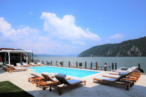 een zwembad met ligstoelen naast het water bij Serenity in Eşelniţa