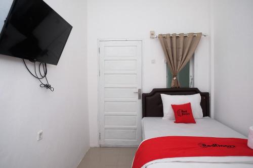 Кровать или кровати в номере RedDoorz Plus At Lovina Inn Tonrangeng River Side