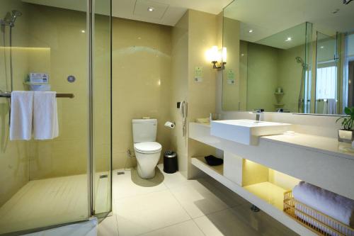y baño con aseo, lavabo y ducha. en Wudang International Hotel en Shiyan