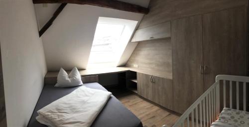 a small bedroom with a bed and a window at POSTRELAIS ARDENNES "Belle-Vue" in Burg-Reuland
