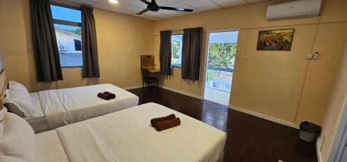 ein Hotelzimmer mit 2 Betten und einem Fenster in der Unterkunft Starry night homestay in Kota Kinabalu