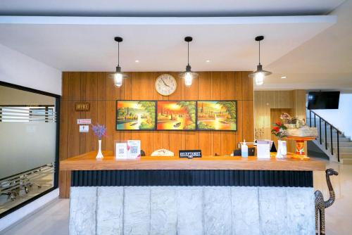 a kitchen with a bar with a clock on the wall at Urbanview Pecatu Residence Bali by RedDoorz in Uluwatu