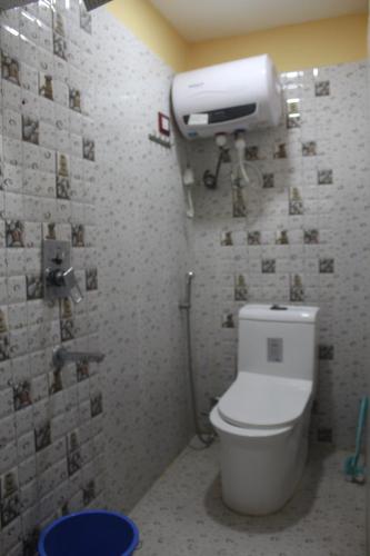 a bathroom with a toilet and a paper dispenser on the wall at Hotel Giggle Coast Restro and Lodge in Birtamode