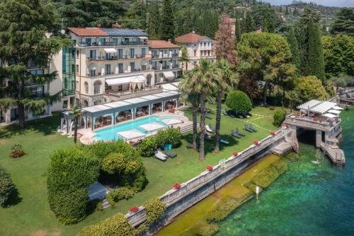 an aerial view of a house with a pool and a river at Hotel Villa Capri in Gardone Riviera