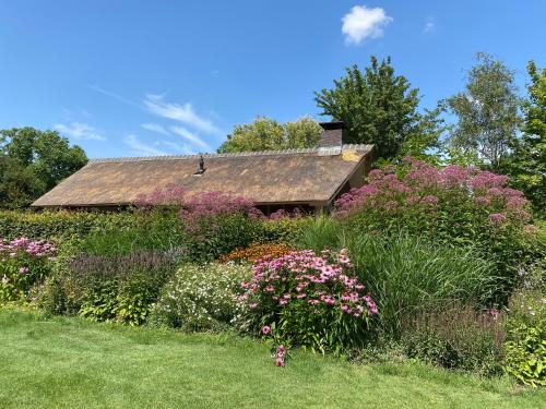 een tuin met bloemen voor een huis bij Het Beregoed in Malden