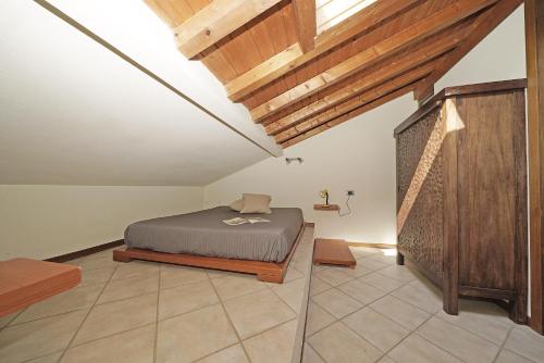 1 dormitorio con 1 cama en una habitación con techos de madera en Borgo Alto P1-16 by Wonderful Italy, en Puegnago sul Garda