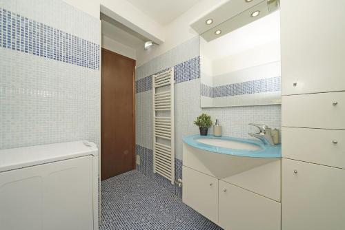 baño con lavabo y un baño azul y blanco en Borgo Alto P1-16 by Wonderful Italy en Puegnago