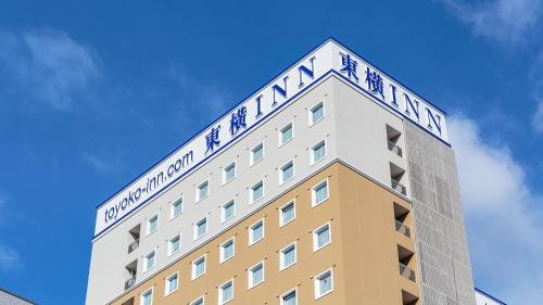a building with a sign on top of it at Toyoko Inn Nagoya Kanayama in Nagoya