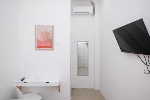 Habitación blanca con TV y lavabo blanco en RedDoorz Plus At Lovina Inn Tonrangeng River Side, en Parepare