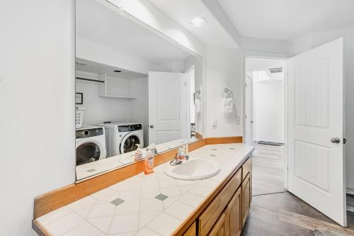 Un baño con lavabo y lavadora. en The Whaler, en Rockaway Beach