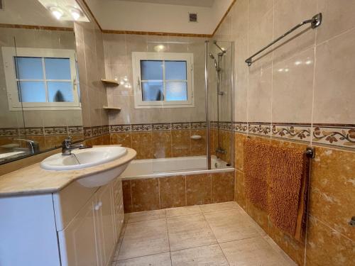 a bathroom with a sink and a shower and a tub at Villa Rosa in Costa Teguise