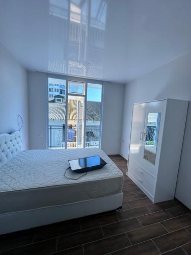 een slaapkamer met een bed en een groot raam bij KOBULETI REZIDENS in Kobuleti