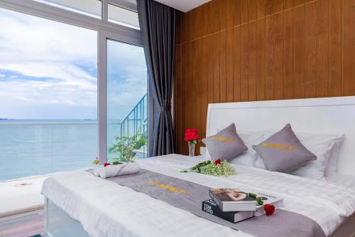 a bedroom with a large bed with a large window at Palm Villa 23 (Beachfront Pool Villa Vung Tau with an Ocean view and Karaoke, Billards) in Vung Tau