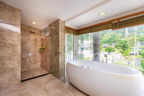 a large bathroom with a tub and a shower at Palm Villa 23 (Beachfront Pool Villa Vung Tau with an Ocean view and Karaoke, Billards) in Vung Tau