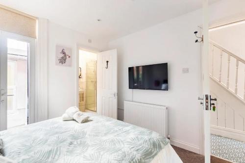 a white bedroom with a bed and a flat screen tv at Northumberland Boutique Guest House #2 in Coventry