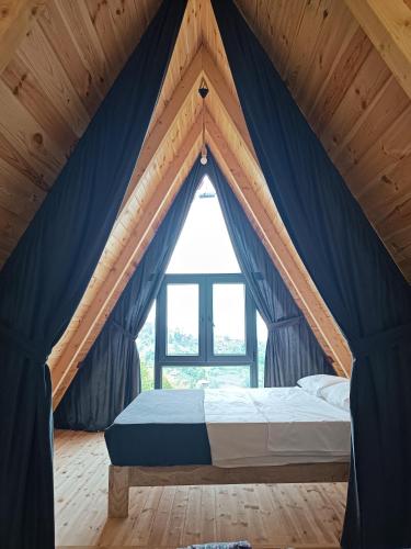 a bed in a room with a large window at Mira bungalov rize in Ardeşen