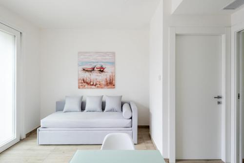 a white living room with a white couch at ISA-Residence with swimming-pool in Stintino near the famous La Pelosa-beach in Stintino