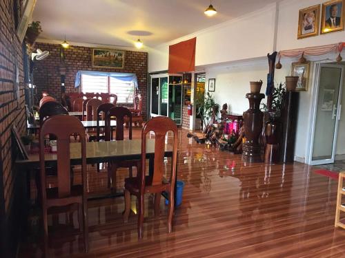 a dining room with a table and chairs on a wooden floor at Manel Guesthouse and Restaurant in Sen Monorom