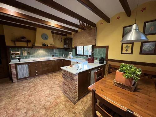 a large kitchen with a wooden table and a counter at Casa Campo cerca del Mar y Golf in Elche