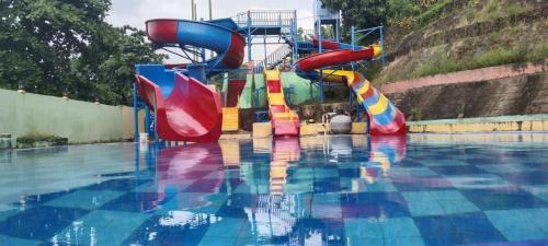 - un toboggan coloré dans la piscine dans l'établissement kahai beach hotel, à Waimuli