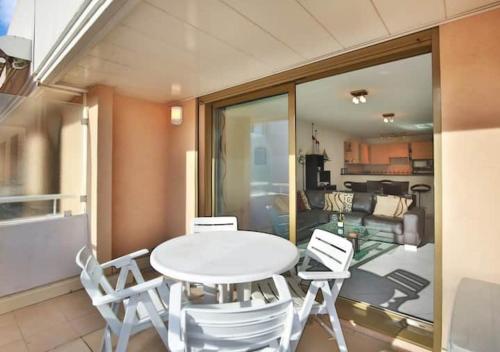 une salle à manger avec une table et des chaises blanches dans l'établissement Charming Two-Bedroom Apartment with balcony and Garage by the Marina, à Antibes