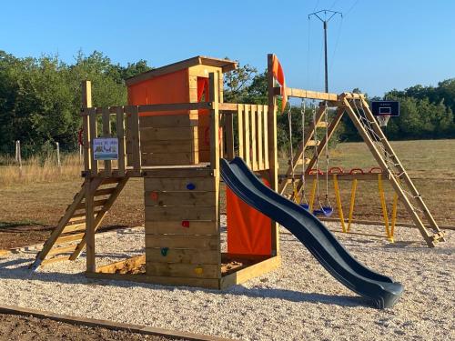 a wooden playground with a slide and a slideintend at La Ferme Des Vergnes in Gabillou