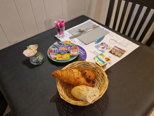 a table with a basket of bread and snacks at Le Gue de Genes in Ambrieres Les Vallees