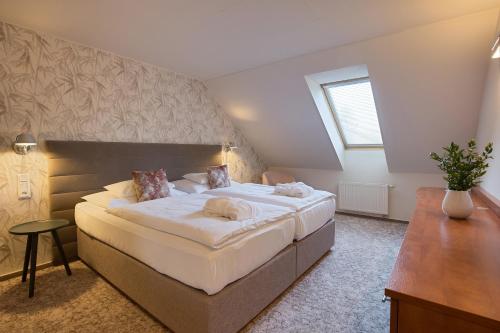 a bedroom with a large bed and a desk at Equitana Hotel Resort in Březnice