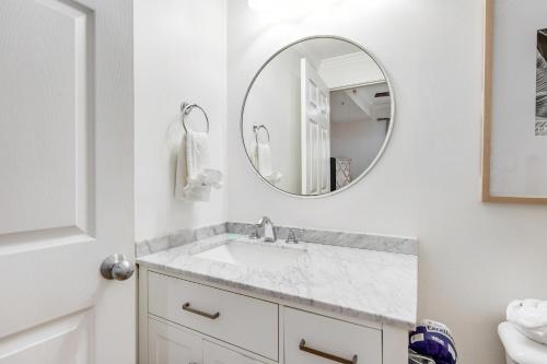 Un baño blanco con lavabo y espejo. en South Harbour 07B, en Pensacola Beach
