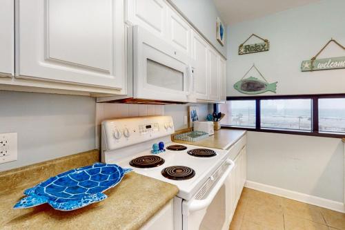 a kitchen with white cabinets and a stove top oven at Palm Beach Club 2-228 in Pensacola Beach