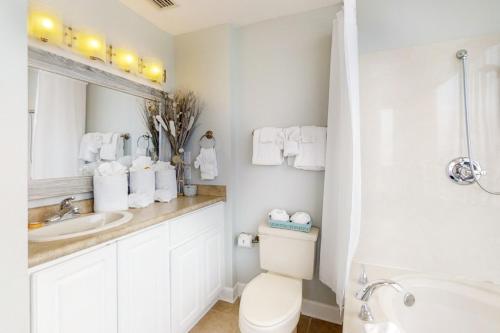 a white bathroom with a toilet and a sink at Palm Beach Club 2-228 in Pensacola Beach