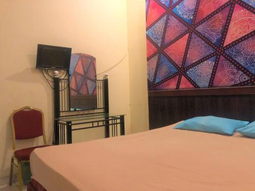 a bedroom with a bed and a dresser and a mirror at Wisma Idola Palopo in Palopo