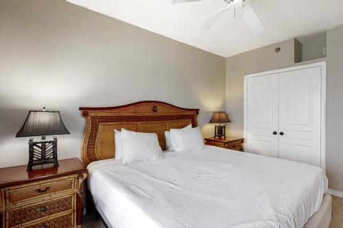 ein Schlafzimmer mit einem großen weißen Bett mit zwei Nachttischen in der Unterkunft Emerald Isle 0603 in Pensacola Beach