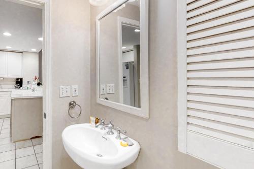 ein weißes Badezimmer mit einem Waschbecken und einem Spiegel in der Unterkunft Emerald Isle 0603 in Pensacola Beach
