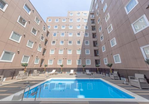 a swimming pool in front of a building at APA Hotel & Resort Tokyo Bay Shiomi in Tokyo