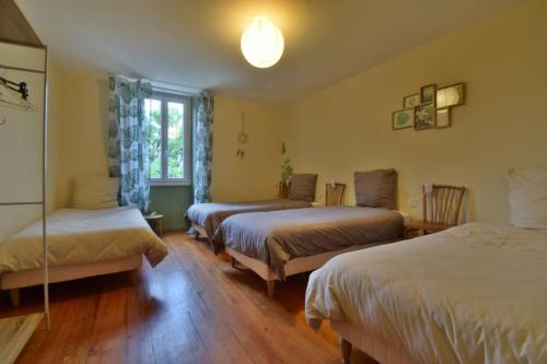 ein Hotelzimmer mit 3 Betten und einem Fenster in der Unterkunft Gîte Le Bon Sens - Domaine la Rose des vents in Castelnau-sur-lʼAuvignon
