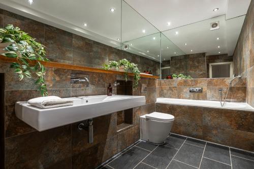 a bathroom with a sink and a tub and a toilet at Fashionable Brick Lane in London