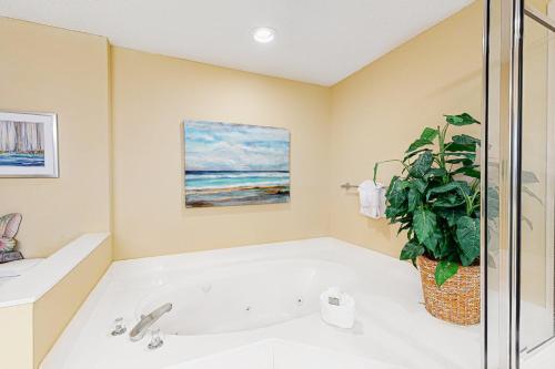 a bath tub with a plant in a bathroom at Pearl 1602 in Navarre