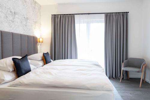 a bedroom with a white bed and a window at Equitana Hotel Resort in Březnice