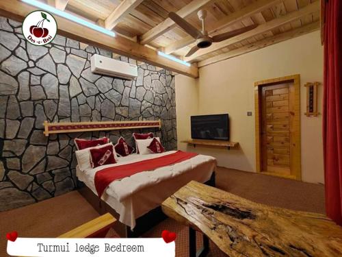 1 dormitorio con cama y pared de piedra en Das-e-Basi, en Gilgit