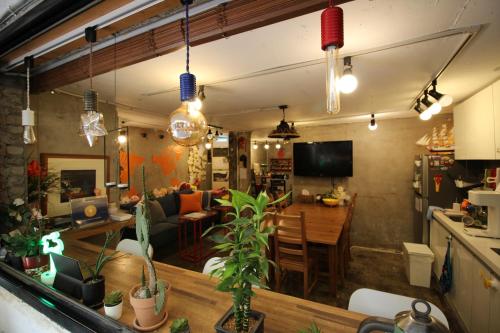 a living room and a kitchen with a table and a couch at Bunk Guesthouse Hongdae in Seoul