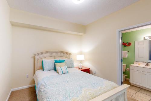 a bedroom with a bed with blue pillows and a sink at Windemere 0805 in Perdido Key