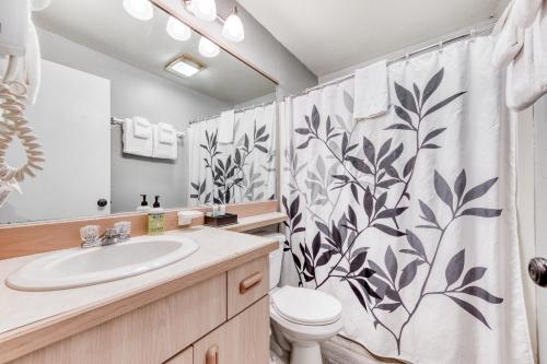 a bathroom with a sink and a toilet and a shower curtain at Sea Treasures Inn #211 & #212 in Rockaway Beach
