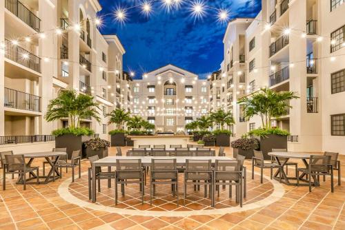 un patio con mesas y sillas en un edificio en Stylish Modern Apartments at Gables Grand Plaza in Miami en Miami