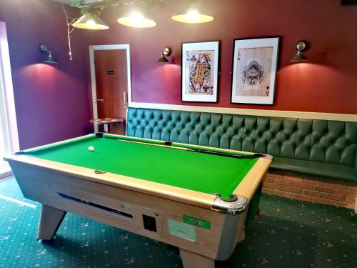 uma sala de bilhar com uma mesa de bilhar verde em Kings Inn Public House 