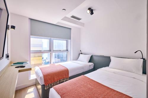 a hotel room with two beds and a window at South Nest in Hong Kong