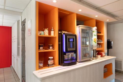 eine Küche mit einer Theke, einer Mikrowelle und einem Kühlschrank in der Unterkunft Première Classe Châlons-en-Champagne in Saint-Martin-sur-le-Pré