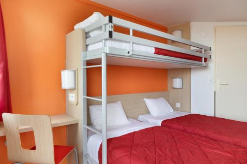 a bedroom with two bunk beds and a red bed at Première Classe Châlons-en-Champagne in Châlons-en-Champagne